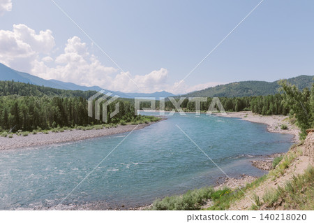 Scenic turquoise river bend in Altai Mountains with forested hills and blue sky Scenic turquoise river bend in Altai Mountains with forested hills and blue sky 140218020