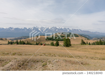 Wide panorama of Kurai Steppe with snowy Altai mountains under cloudy sky Wide panorama of Kurai Steppe with snowy Altai mountains under cloudy sky 140218040