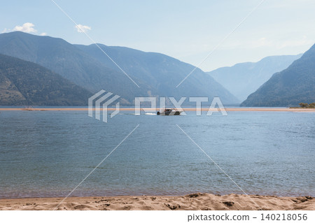Speedboat on Teletskoye Lake with mountain valley landscape in Altai region Speedboat on Teletskoye Lake with mountain valley landscape in Altai region 140218056