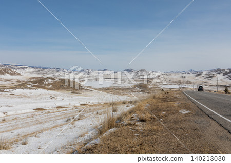 Winter road through Tazheran steppe with snow fields and distant hills panorama Winter road through Tazheran steppe with snow fields and distant hills panorama 140218080