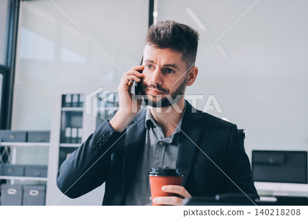 Tired worker. A tired businessman works in the evening. A man in office clothes is holding his temples. Problems in business. The businessman is trying to solve the problems that have arisen. 140218208
