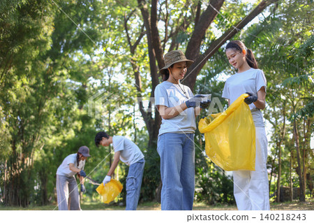 Group of Young Volunteer Help Cleaning Public Park Collecting Garbages and Plastic Waste 140218243