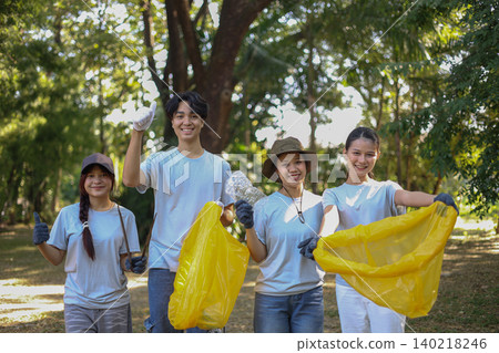 Group of Young Volunteer Help Cleaning Public Park Collecting Garbages and Plastic Waste 140218246