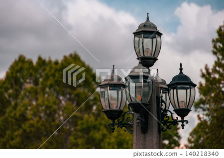 Vintage Ornate Street Lamp Against Dramatic Cloudy Sky, Decorative Urban Lighting Fixture Vintage Ornate Street Lamp Against Dramatic Cloudy Sky, Decorative Urban Lighting Fixture 140218340