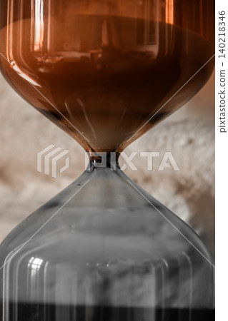 Close Up Glass Hourglass with Flowing Sand Close Up Glass Hourglass with Flowing Sand 140218346
