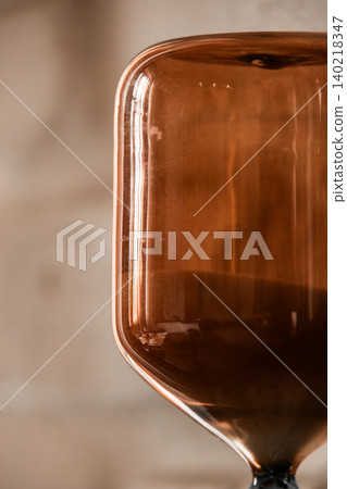 Close Up Glass Hourglass with Flowing Sand Close Up Glass Hourglass with Flowing Sand 140218347
