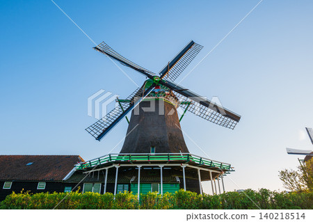 Close up of traditional dutch windmill with thatched roof against blue sky at sunset, historic wooden mill architecture in zaanse schans netherlands tourism landmark Close up of traditional dutch windmill with thatched roof against blue sky at sunset, historic wooden mill architecture in zaanse schans netherlands tourism landmark 140218514