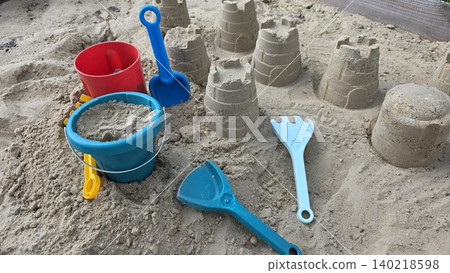 Children's sand toys and buckets in a sandbox, playful summer activity for kids, outdoor fun, learning, and creative play. Children's sand toys and buckets in a sandbox, playful summer activity for kids, outdoor fun, learning, and creative play. 140218598
