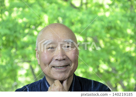 An elderly person relaxing amidst the fresh greenery, with a smile on their face. An elderly person relaxing amidst the fresh greenery, with a smile on their face. 140219185