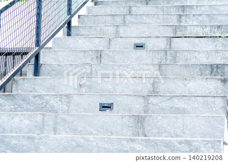 Outdoor concrete staircase with metal railing and integrated step lights in a modern architectural setting Outdoor concrete staircase with metal railing and integrated step lights in a modern architectural setting 140219208
