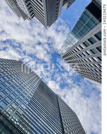 Looking up at the skyscrapers and the blue sky, office buildings in the business district. Looking up at the skyscrapers and the blue sky, office buildings in the business district. 140219479