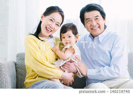 A close-knit family relaxing on the living room sofa. 140219740