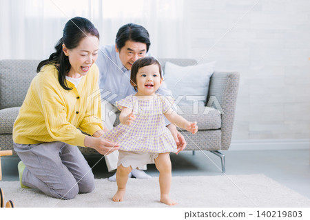 Children and family playing in the living room: infants, grandmother, grandfather Children and family playing in the living room: infants, grandmother, grandfather 140219803