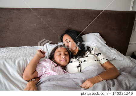 A woman and a child are sleeping in bed A woman and a child are sleeping in bed 140221249