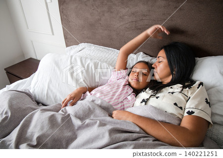 A woman and a child are sleeping in bed A woman and a child are sleeping in bed 140221251