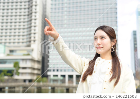 Japanese businesswoman points in the office district. Japanese businesswoman points in the office district. 140221508