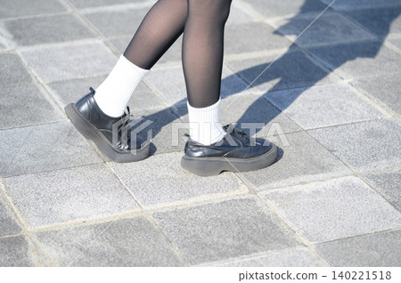 The feet of a high school girl standing outdoors 140221518