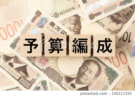 一塊標示「預算規劃」的紙牌和大量10,000日圓面額的鈔票。 一塊標示「預算規劃」的紙牌和大量10,000日圓面額的鈔票。 140221593