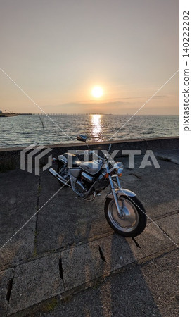 A motorcycle riding in the setting sun A motorcycle riding in the setting sun 140222202