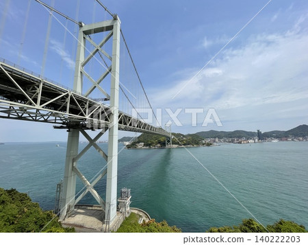 The Kanmon Strait and the majestic Kanmon Bridge under a clear blue sky in early summer. 140222203