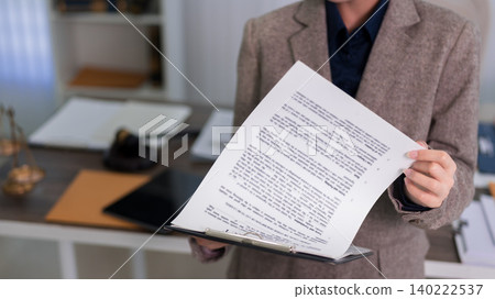 professional lawyer holding legal document contract paper business office reviewing agreement paperwork corporate attorney workplace white desk modern workspace professional lawyer holding legal document contract paper business office reviewing agreement paperwork corporate attorney workplace white desk modern workspace 140222537