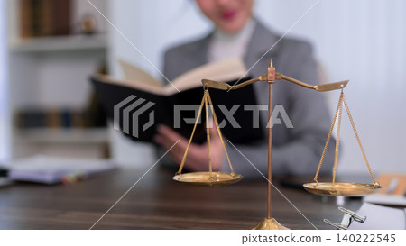 professional lawyer reading law book at office desk with golden scales of justice legal consultation law firm attorney studying legal case research legal 140222545