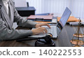 professional lawyer attorney using laptop computer working legal case research writing legal document at law firm office desk with gavel justice scales books 140222553