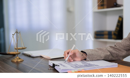 lawyer attorney reviewing contract document at desk in modern law office with justice scale symbol reviewing legal paperwork for client consultation lawyer attorney reviewing contract document at desk in modern law office with justice scale symbol reviewing legal paperwork for client consultation 140222555