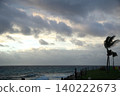 Palm trees swaying in the strong wind on the beach. 140222673