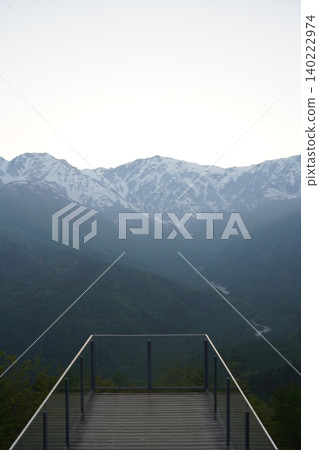 A terrace overlooking the mountains with lingering snow and fresh greenery. A terrace overlooking the mountains with lingering snow and fresh greenery. 140222974