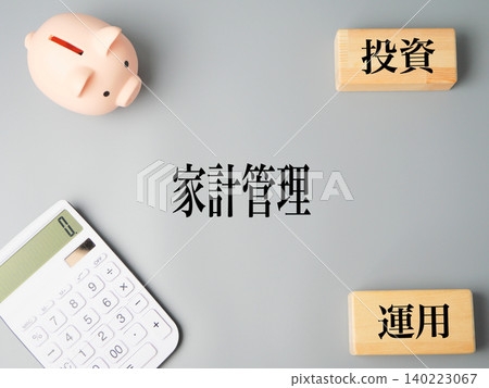 家庭預算管理和儲蓄的象徵：計算器、存錢筒和木塊。 140223067