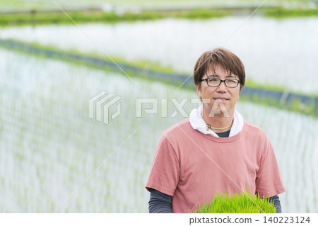 A farmer holding rice seedlings A farmer holding rice seedlings 140223124