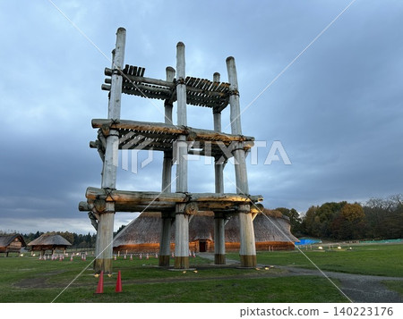 This is a reconstruction of a large post-supported building and a large pit dwelling visible behind it, both located at the Sannai-Maruyama archaeological site, a Jomon period site in Aomori City. This is a reconstruction of a large post-supported building and a large pit dwelling visible behind it, both located at the Sannai-Maruyama archaeological site, a Jomon period site in Aomori City. 140223176