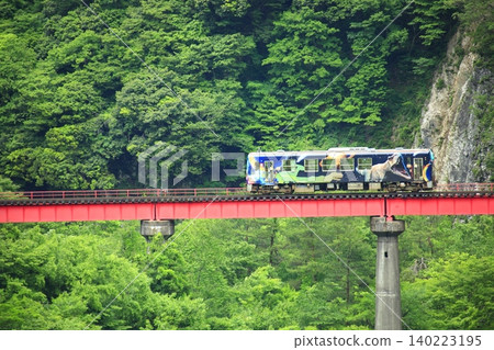 A local train crossing a red railway bridge A local train crossing a red railway bridge 140223195