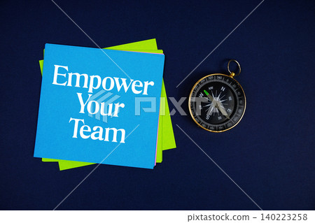 Empower Your Team text written on sticky note with compass on blue background Empower Your Team text written on sticky note with compass on blue background 140223258