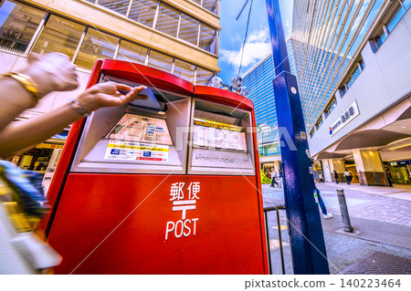 A view of the Tokyo cityscape, including the postboxes in front of Yokohama Station's West Exit 5th Avenue. A view of the Tokyo cityscape, including the postboxes in front of Yokohama Station's West Exit 5th Avenue. 140223464