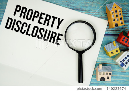 Notepad with "Property Disclosure" with magnifying glass and house model on wooden background Notepad with "Property Disclosure" with magnifying glass and house model on wooden background 140223674