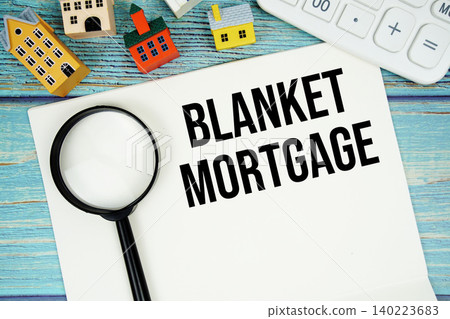 Notepad with "Blanket Mortgage" with Calculator, magnifying glass and house model on wooden background 140223683