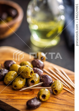 Marinated Olives On Wooden Board With Toothpicks And Olive Oil For Appetizer Platter 140224901
