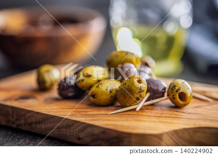 Marinated Olives On Wooden Board With Toothpicks And Olive Oil For Appetizer Platter Marinated Olives On Wooden Board With Toothpicks And Olive Oil For Appetizer Platter 140224902