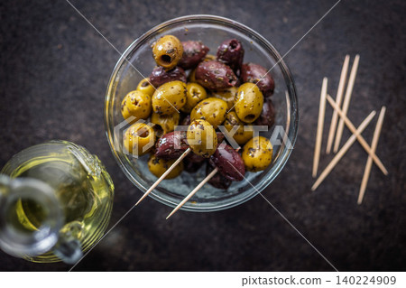 Marinated Green And Kalamata Olives In Glass Bowl With Olive Oil And Toothpicks Marinated Green And Kalamata Olives In Glass Bowl With Olive Oil And Toothpicks 140224909