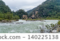 Namnam River flows through rocky banks and lush green pine forest in Mugla, Turkey. Wild mountain river landscape under a cloudy sky. 140225138