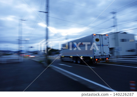 A van-type work vehicle speeding down the road in the early morning: Yamato Transport chartered delivery. A van-type work vehicle speeding down the road in the early morning: Yamato Transport chartered delivery. 140226287