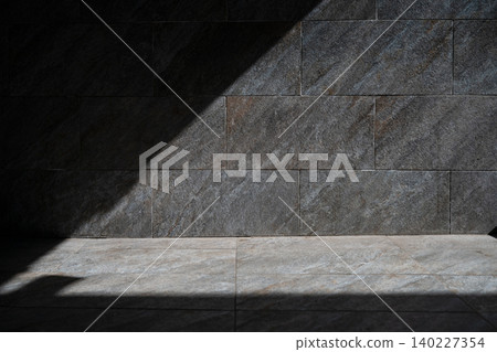 Minimalist architectural background with dramatic light and shadow contrast on marble texture. Empty dark and light stone wall mockup space on a bright sunny day. Minimalist architectural background with dramatic light and shadow contrast on marble texture. Empty dark and light stone wall mockup space on a bright sunny day. 140227354