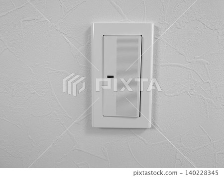 Residential light switch installed on a white painted wall Residential light switch installed on a white painted wall 140228345