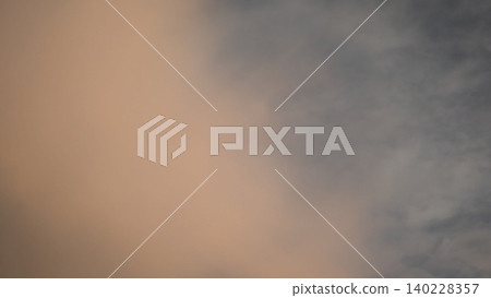 Wide scenic view captures soft altocumulus cloud layers at dawn. Minimalist pink orange sunrise light illumination blends over dark sky details, creating a beautiful abstract background template. Wide scenic view captures soft altocumulus cloud layers at dawn. Minimalist pink orange sunrise light illumination blends over dark sky details, creating a beautiful abstract background template. 140228357