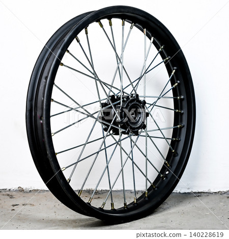 Black motorcycle wheel rim in perspective view with silver spoke and hub isolated on white background for motorbike custom tuning and spare repair part 140228619
