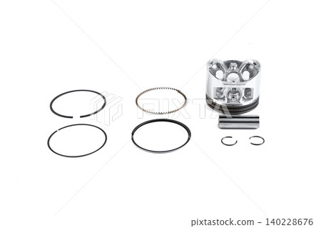 Motorcycle engine piston assembly rebuild kit with rings and pin on white top view. Motorcycle engine piston assembly rebuild kit with rings and pin on white top view. 140228676