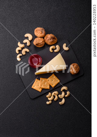 Aged cheese in a triangular block with jam, figs, and nuts. Aged cheese Aged cheese in a triangular block with jam, figs, and nuts. Aged cheese 140228953