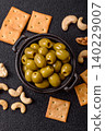 Whole green olives without pits in a bowl as an ingredient for cooking at home. Green olives 140229007